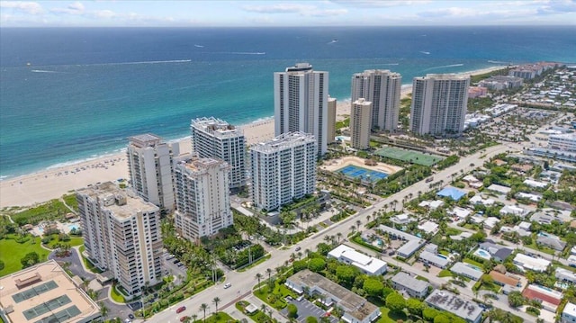 birds eye view of property with a water view and a beach view