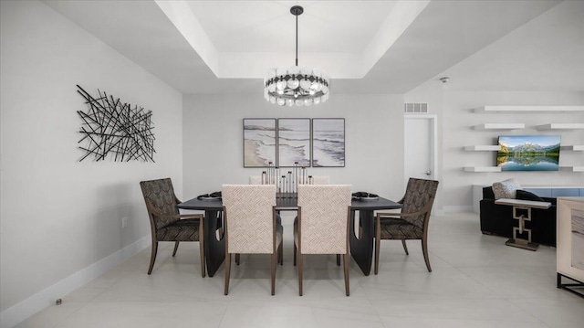 dining area featuring an inviting chandelier and a tray ceiling