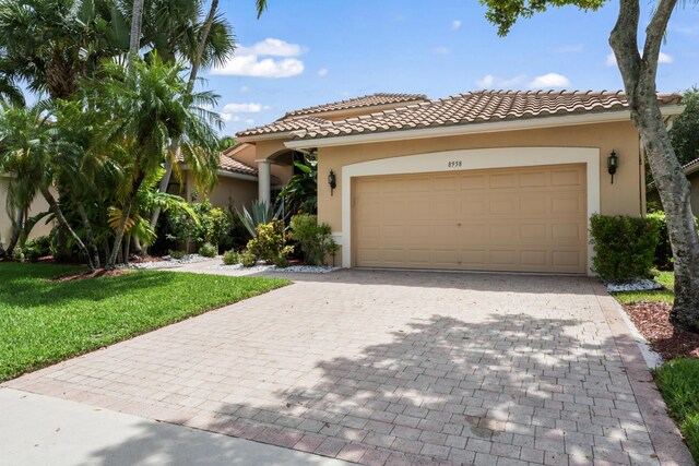 mediterranean / spanish-style house featuring a garage and a front yard