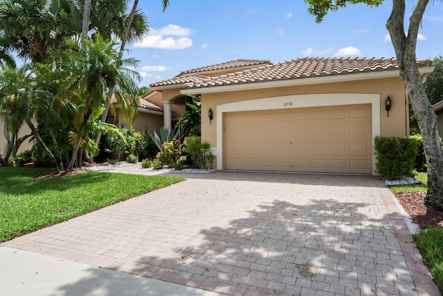 mediterranean / spanish-style house featuring a garage and a front lawn