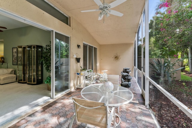 sunroom featuring lofted ceiling and ceiling fan