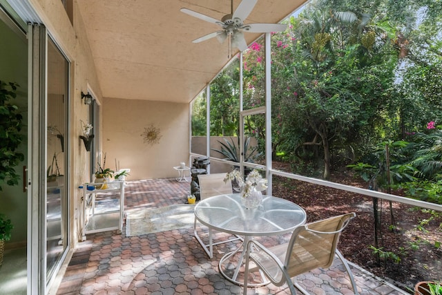 unfurnished sunroom with ceiling fan and vaulted ceiling