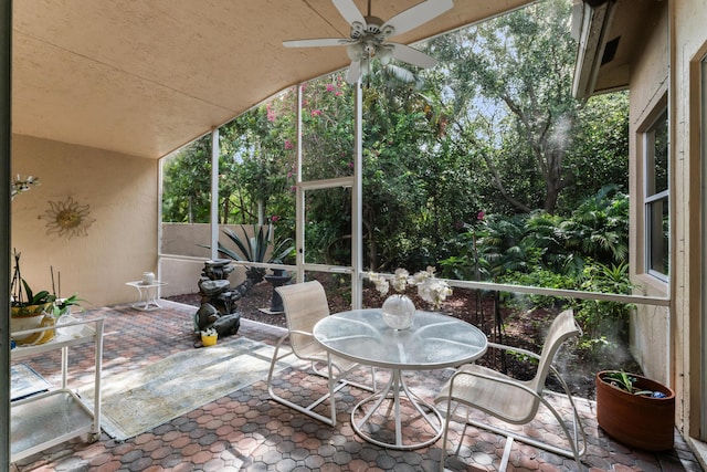 sunroom with ceiling fan and vaulted ceiling