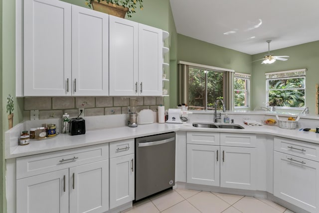 kitchen with sink, light tile patterned floors, stainless steel dishwasher, ceiling fan, and white cabinets