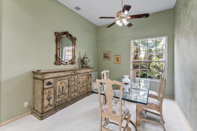 carpeted dining space with ceiling fan