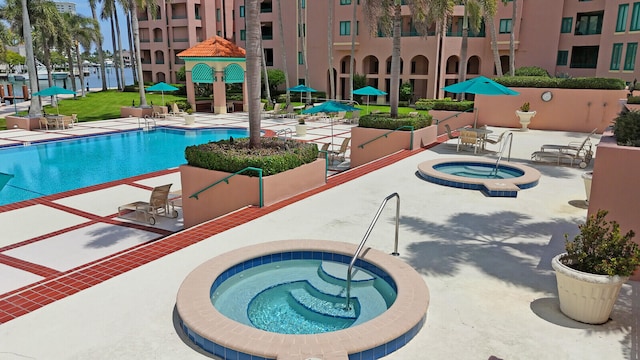 view of pool with a patio and a hot tub