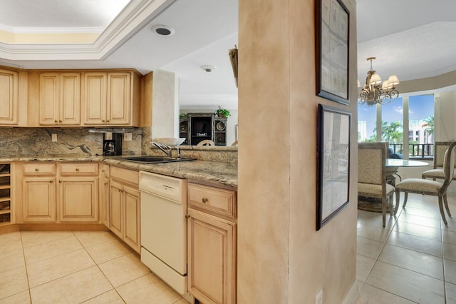 kitchen featuring an inviting chandelier, backsplash, white dishwasher, light stone counters, and sink