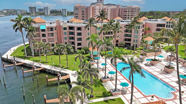 view of pool featuring a water view, a boat dock, and a yard