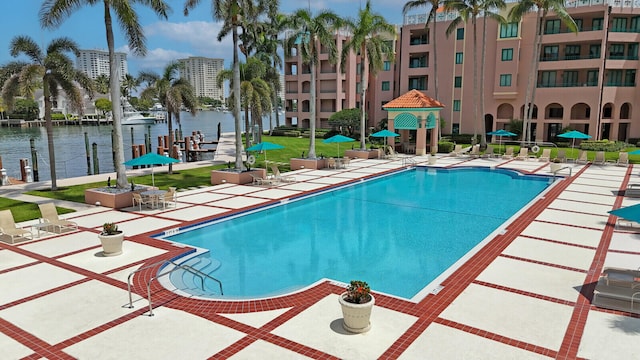 view of swimming pool with a water view and a patio