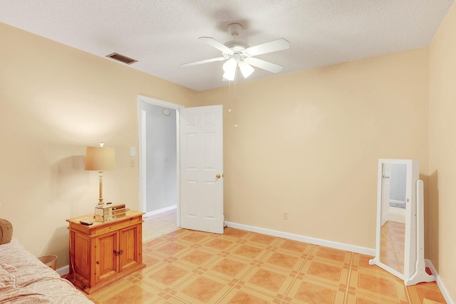 tiled bedroom with a textured ceiling and ceiling fan