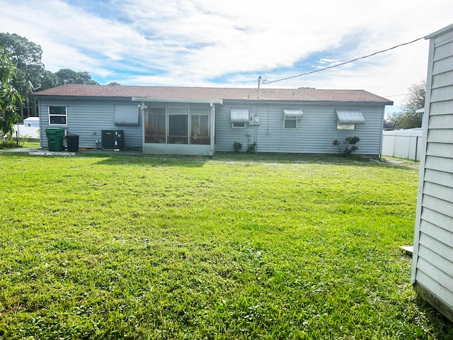 back of property featuring central AC and a yard