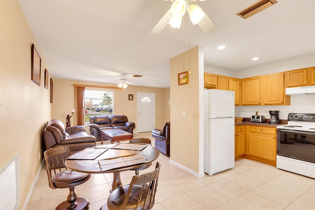 kitchen featuring light brown cabinetry, light tile patterned floors, ceiling fan, and white appliances