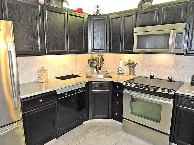 kitchen featuring light tile patterned flooring, decorative backsplash, stainless steel appliances, and sink