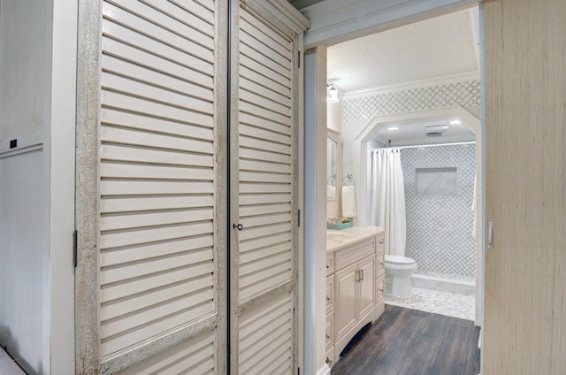 bathroom featuring hardwood / wood-style floors, a shower with shower curtain, vanity, a textured ceiling, and toilet