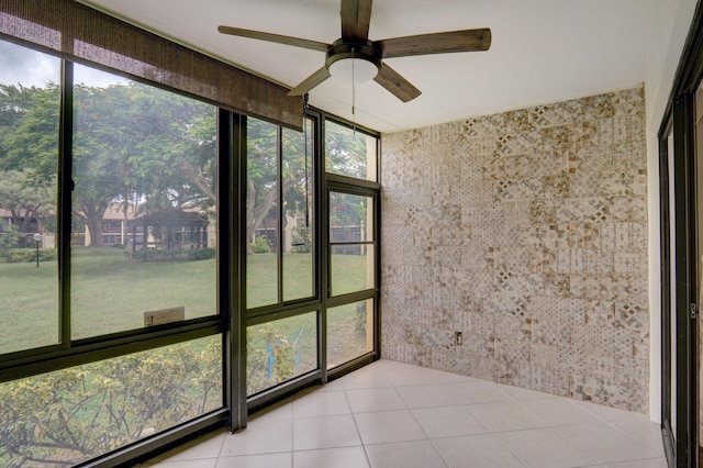 unfurnished sunroom with ceiling fan