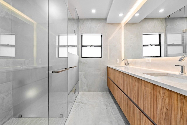 bathroom featuring vanity, a shower with door, and tile walls