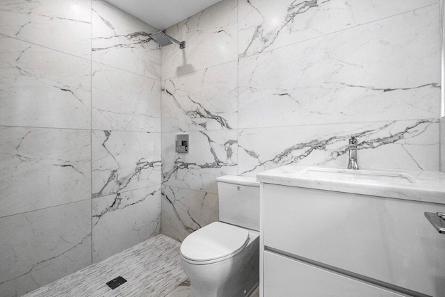 bathroom with vanity, a tile shower, and toilet