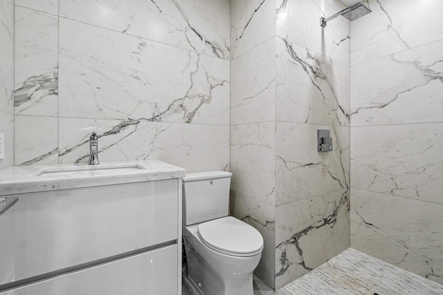 bathroom with vanity, toilet, and a tile shower