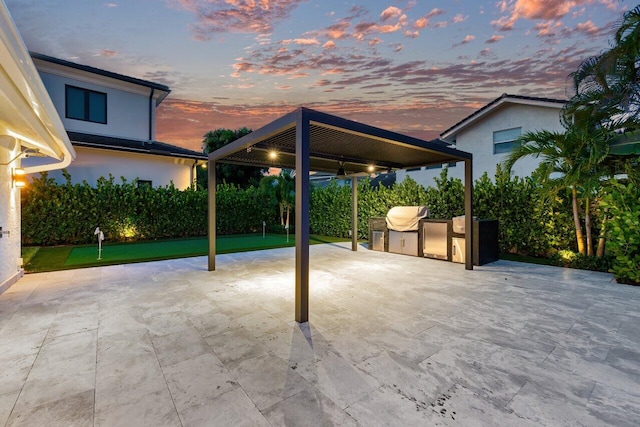 patio terrace at dusk featuring exterior kitchen