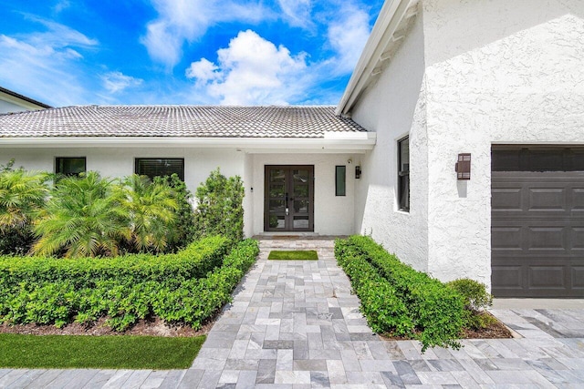 entrance to property featuring a garage and french doors