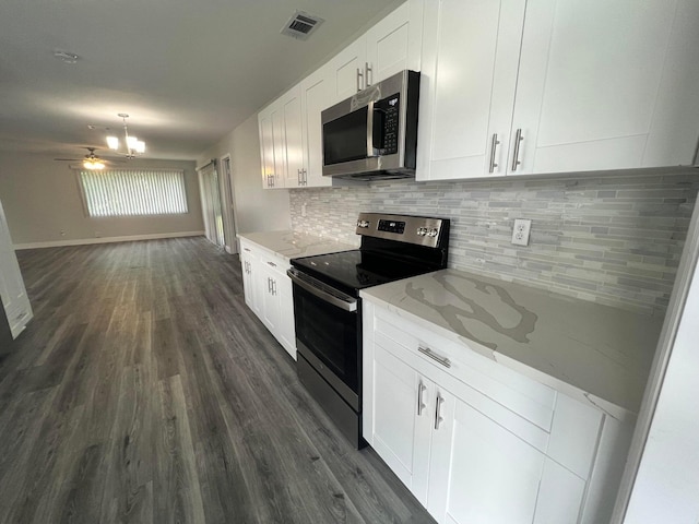 kitchen featuring appliances with stainless steel finishes, white cabinets, decorative backsplash, light stone countertops, and dark hardwood / wood-style flooring