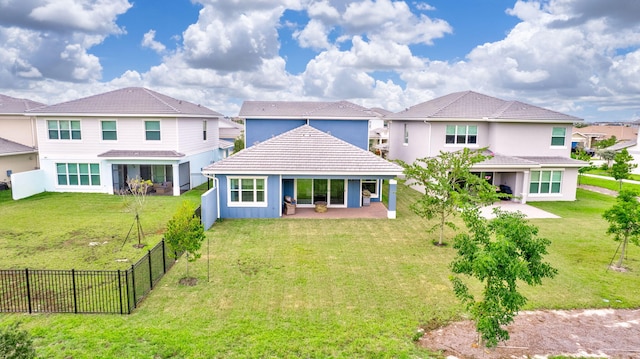 rear view of house featuring a lawn and a patio area