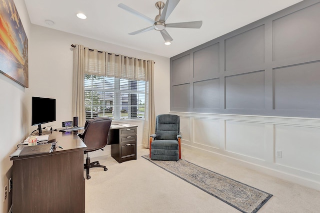 carpeted home office featuring ceiling fan