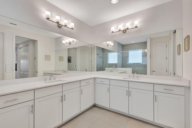 bathroom with a shower with shower door, vanity, and tile patterned flooring