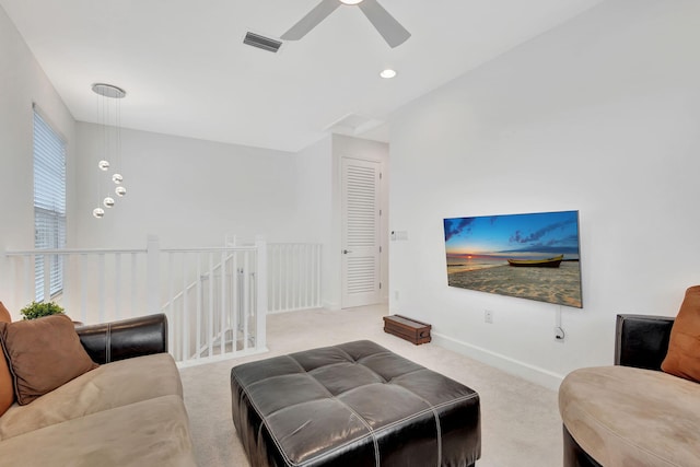 carpeted living room with ceiling fan