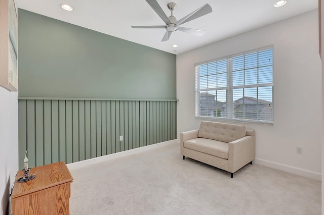 living area with ceiling fan and carpet flooring