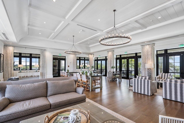 living room with coffered ceiling, dark hardwood / wood-style flooring, french doors, a chandelier, and beamed ceiling