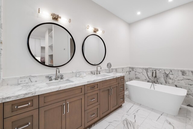 bathroom with double vanity, tile walls, tile patterned floors, and a tub