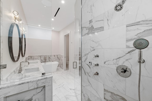 bathroom with a tile shower, double sink vanity, tile walls, and tile patterned flooring