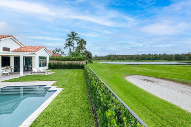 view of yard with a patio area, a water view, and a fenced in pool