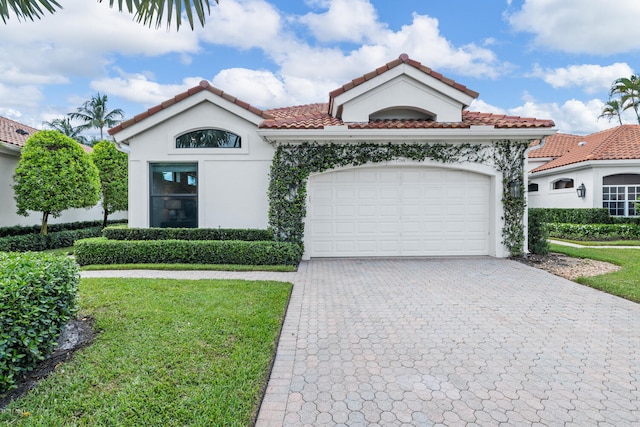 mediterranean / spanish-style house featuring a garage and a front yard