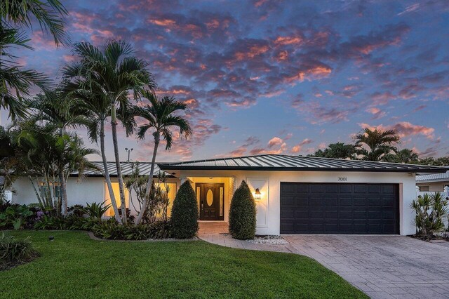 view of front of house featuring a garage and a lawn