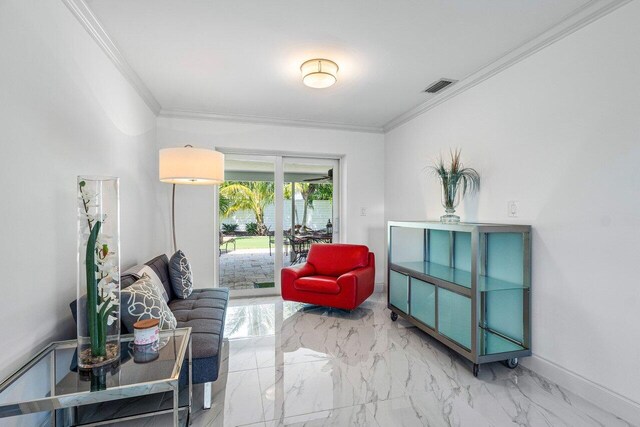 sitting room with ornamental molding and tile patterned flooring