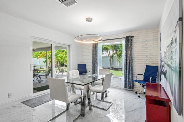 tiled dining area with brick wall and a healthy amount of sunlight