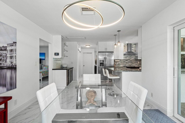 dining room featuring marble finish floor, baseboards, and visible vents