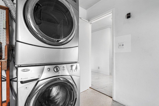 laundry area with light tile patterned floors and stacked washer / drying machine