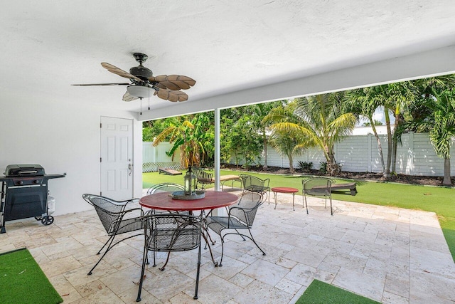 view of patio featuring a grill, outdoor dining space, a ceiling fan, and a fenced backyard