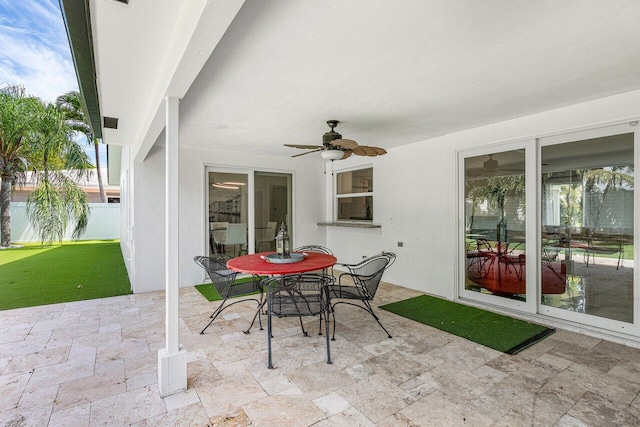 view of patio featuring outdoor dining space, a ceiling fan, and fence