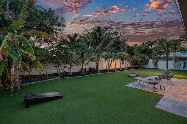 view of property's community featuring a patio, a water view, a fenced backyard, and a lawn