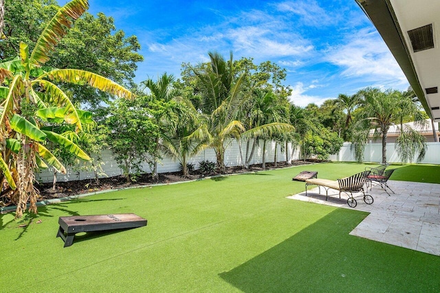 view of property's community with visible vents, a fenced backyard, a yard, and a patio