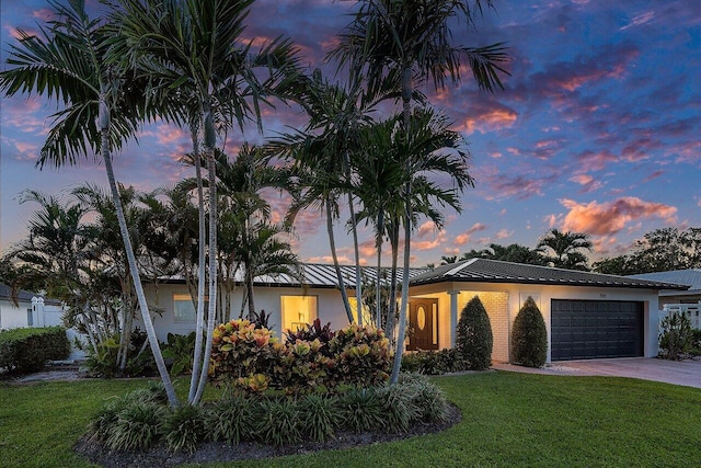 view of front of home with a garage, stucco siding, decorative driveway, and a front lawn