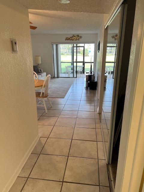 hallway featuring a textured ceiling and light tile patterned floors