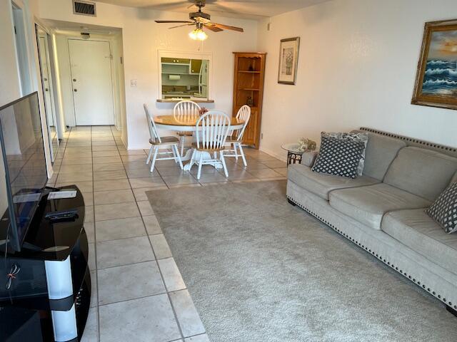 tiled living room featuring ceiling fan