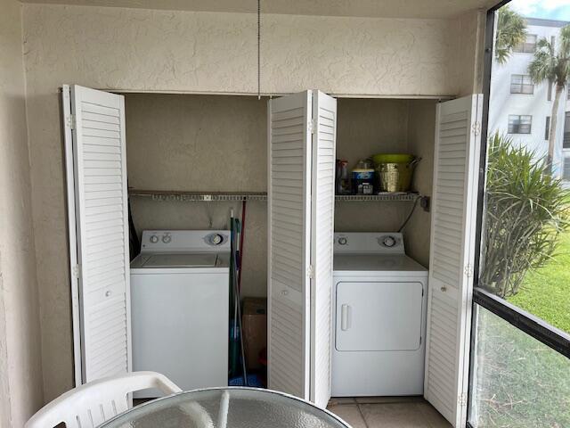 washroom featuring washer / clothes dryer and light tile patterned floors