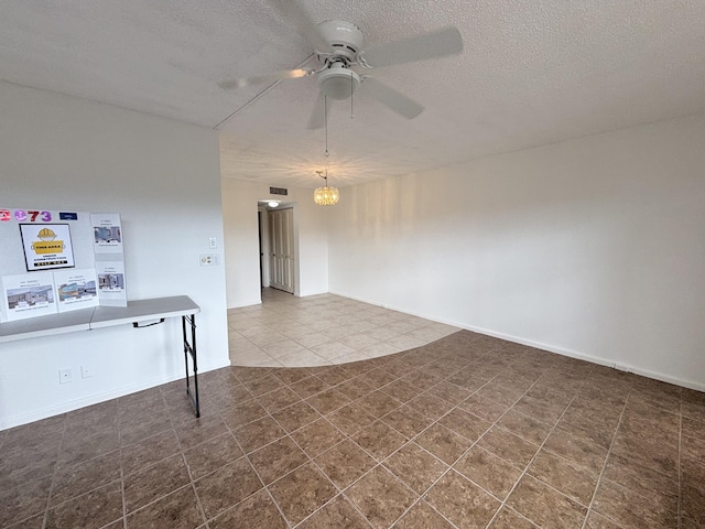 empty room with a textured ceiling and ceiling fan with notable chandelier