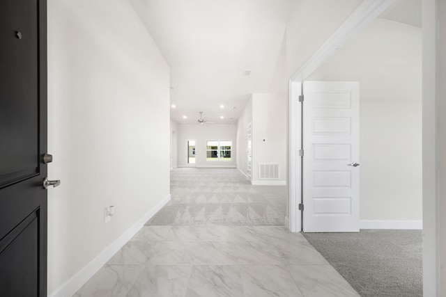 hall with light colored carpet